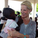 Kronprinsesse Mette-Marit hilser på Trinity (20 mnd) på helseklinikken hvor barn og mødre får hjelp til familieplanlegging og andre helsetilbud. (Foto: Lise Åserud / Scanpix)